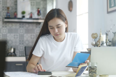 Woman looking at camera while sitting on table