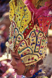 Woman looking away while wearing crown outdoors