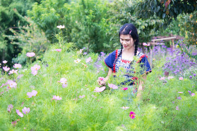 Woman standing by flowering plants