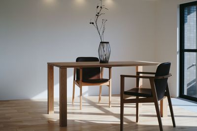 Empty chairs and table against wall at home