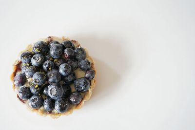 High angle view of blueberry tart against white background