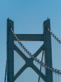 Low angle view of bridge against clear blue sky