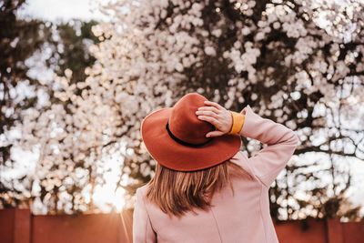 Portrait of woman wearing hat standing against plants