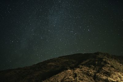 Low angle view of mountain against star field 