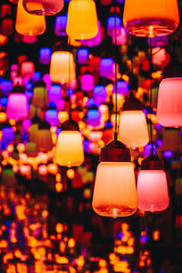 Illuminated lights hanging from ceiling at night