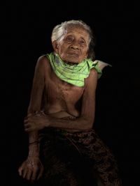 Portrait of a smiling young woman against black background