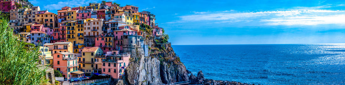 Panoramic view of sea and buildings against sky