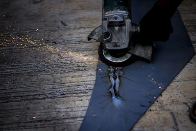 Cropped image of man cutting metal at workshop