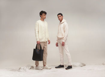 Full length of young woman standing against wall