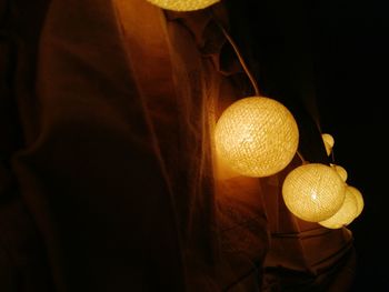 Close-up of illuminated lighting equipment against black background