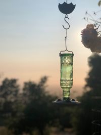 Close-up of light bulb against sky at sunset