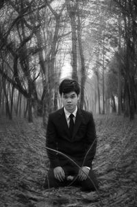 Portrait of young man sitting in forest