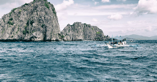 Scenic view of rock formation in sea against sky