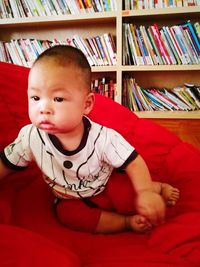 Cute boy sitting on book