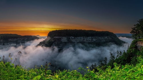 Scenic view of waterfall against sky during sunset