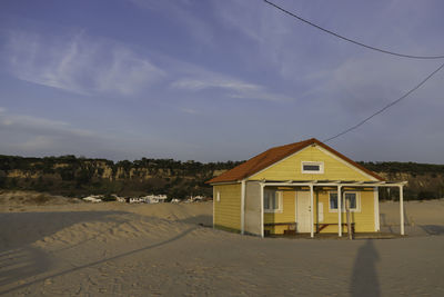 House on beach against sky