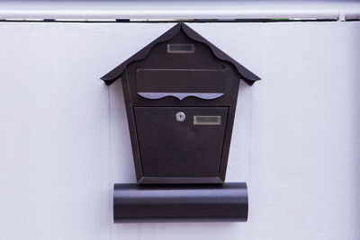 Close-up of birdhouse on wall against building