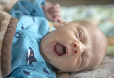 Close-up of cute baby lying on bed