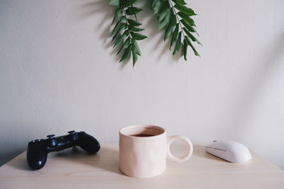 Close-up of coffee cup on table against wall