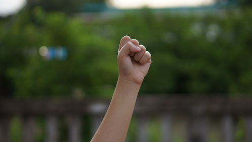 Close-up of persons raised fist outdoors