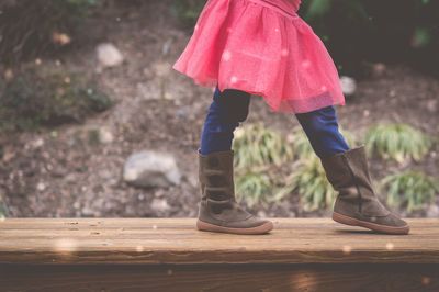 Low section of girl wearing shoes