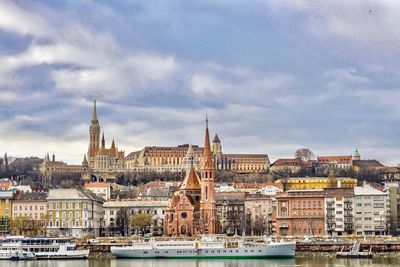 Buildings in city against cloudy sky