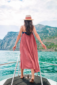 Rear view of woman in sea against sky