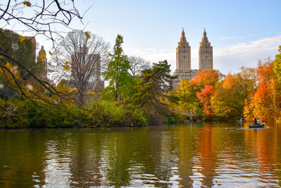 Scenic view of river by buildings against sky