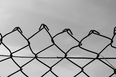 Close-up of wire fence against sky