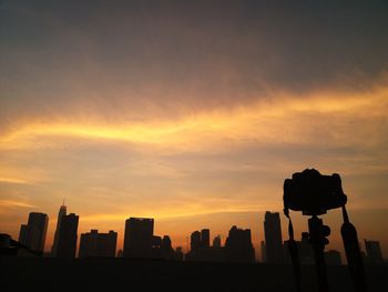 Silhouette buildings against sky during sunset