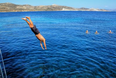 High angle view of man diving in sea against sky