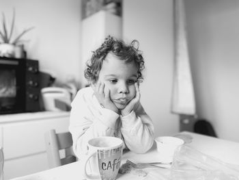 Portrait of young woman drinking coffee at home