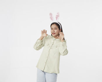 Portrait of smiling girl standing against white background