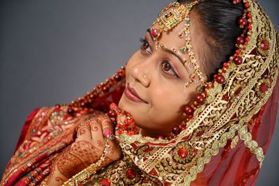 Close-up of smiling young bride against curtain