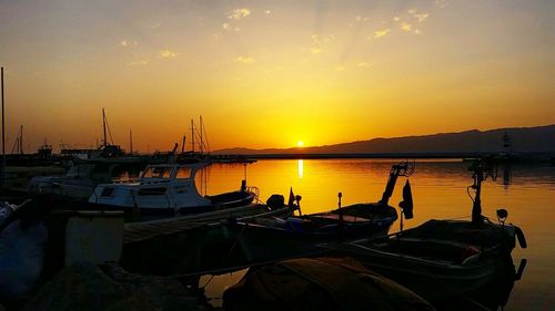 Boats in harbor at sunset