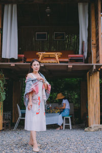 Portrait of woman standing against built structure