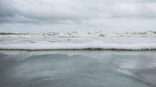 Scenic view of sea against cloudy sky