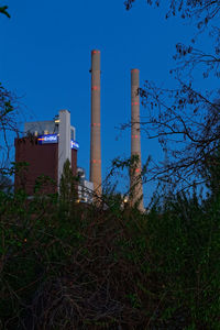 Low angle view of factory against blue sky