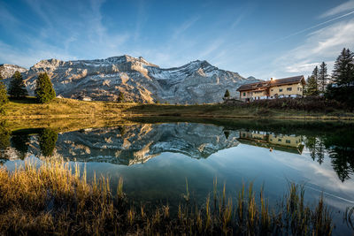 Scenic view of lake by buildings against sky