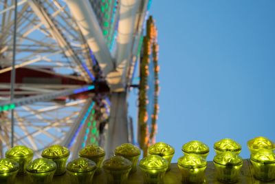 Low angle view of rollercoaster against buildings against clear sky