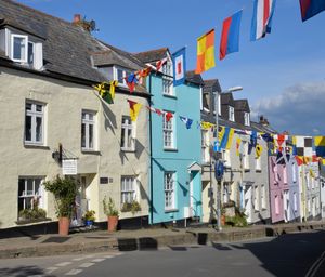 Multi colored flags hanging on street amidst buildings in city