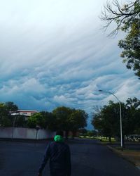 Rear view of man on road against sky