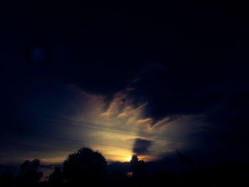 Silhouette of trees against cloudy sky