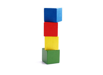 Close-up of multi colored toy blocks stacked over white background