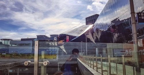 Modern buildings against sky seen through glass window