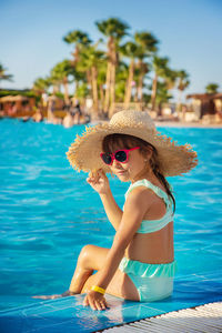 Portrait of young woman sitting in swimming pool