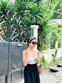 Portrait of woman standing against plants