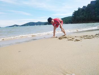 Full length of woman on beach against sky