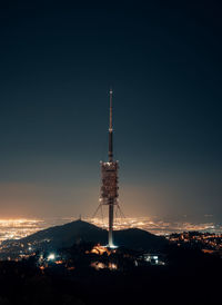 Communications tower against sky at night