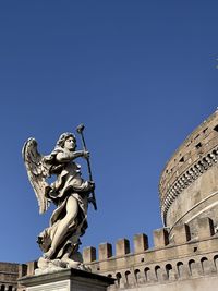 Low angle view of statue against blue sky